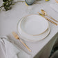 Belo Inox Belo 12 gold cutlery placed beside ceramic plates and blue glassware on a minimalist table