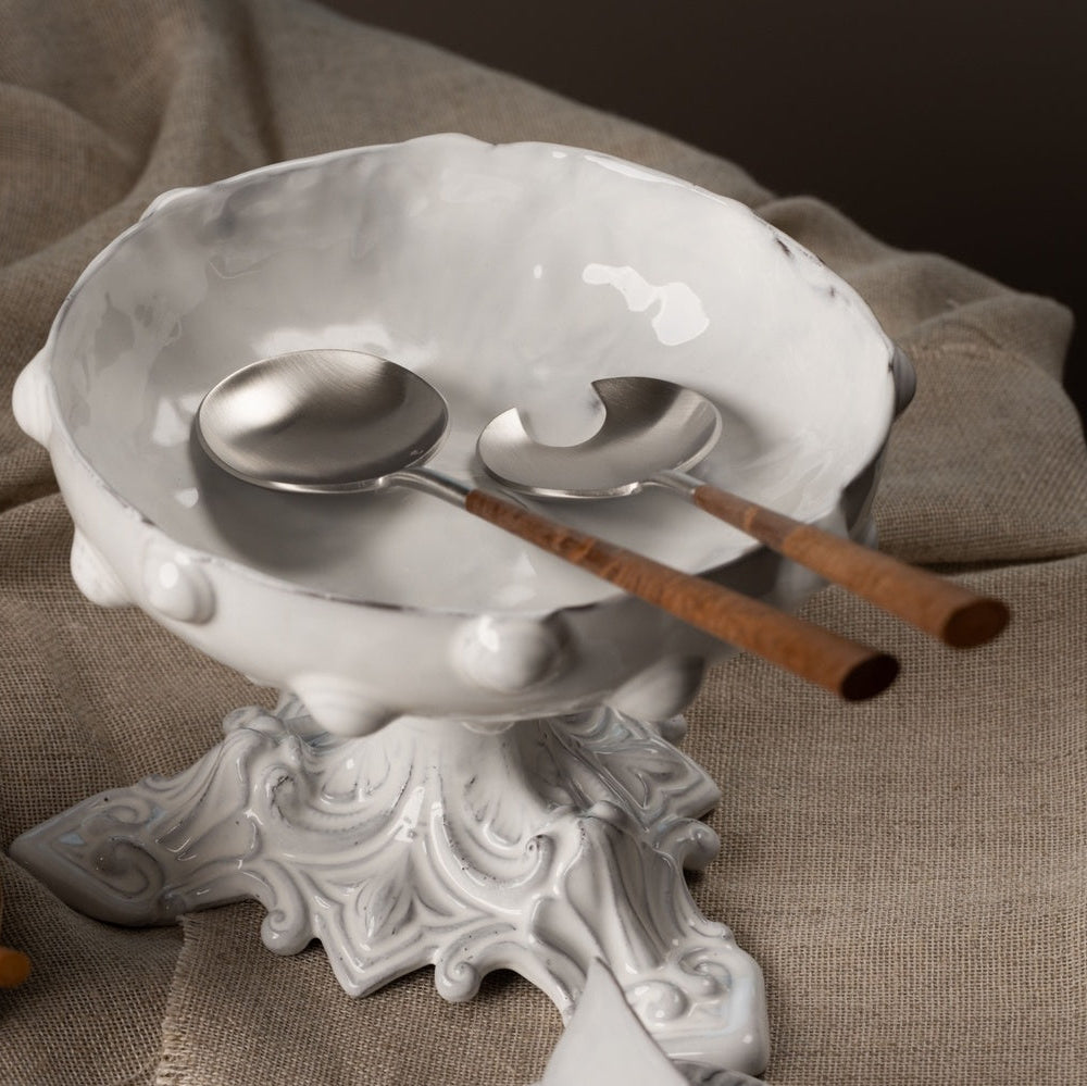 Belo Inox Neo Brown salad serving set in brushed stainless steel with wooden handles, displayed in a white bowl over a beige fabric