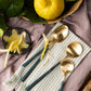 Belo Inox NEO Green cutlery with brushed gold finish displayed on a striped cloth with lemons and zest. Lifestyle photo by Bright Kitchen.
