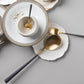 Belo Inox Neo Grey Gold cutlery set with brushed gold heads and grey resin handles displayed on white plates