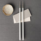 Belo Inox NEO White chopsticks with matte white resin handles and stainless steel tips on a minimalist table setting