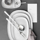 Belo Inox Neo White serving set with stainless steel serving fork and serving spoon on white ceramic plates.