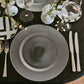 Refined table setting featuring Belo Inox Príncipe cutlery arranged beside a black-and-white patterned plate on a dark elegant surface