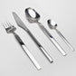 Belo Inox Vertice polished stainless steel flatware set featuring dinner knife, dinner fork, tablespoon and teaspoon on a light background