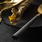 Close-up of Belo Inox Yume cutlery with black resin handle and brushed gold finish