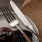 Close-up of Herdmar NOHC cutlery set in stainless steel with textured brown handles and elegant table setting.