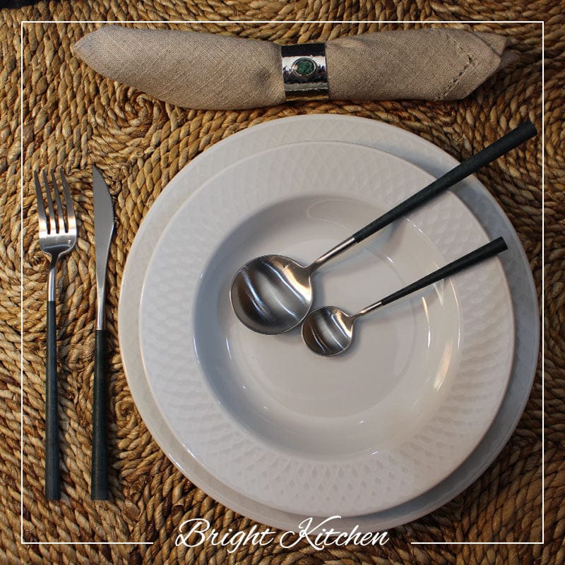 Belo Inox NEO Black cutlery set styled on a white plate with natural table mat – modern Portuguese table setting by Bright Kitchen