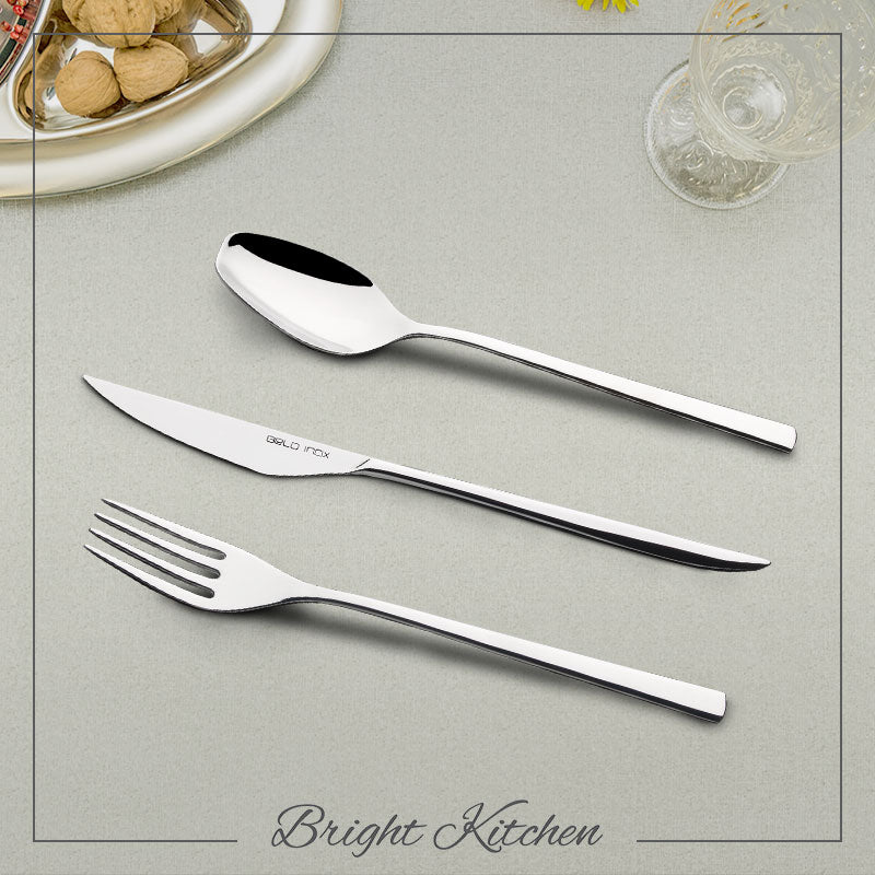 Belo Inox Obelisko cutlery set in polished 18/10 stainless steel, featuring a sleek modern design with knife, fork and spoon on an elegant table setting by Bright Kitchen.