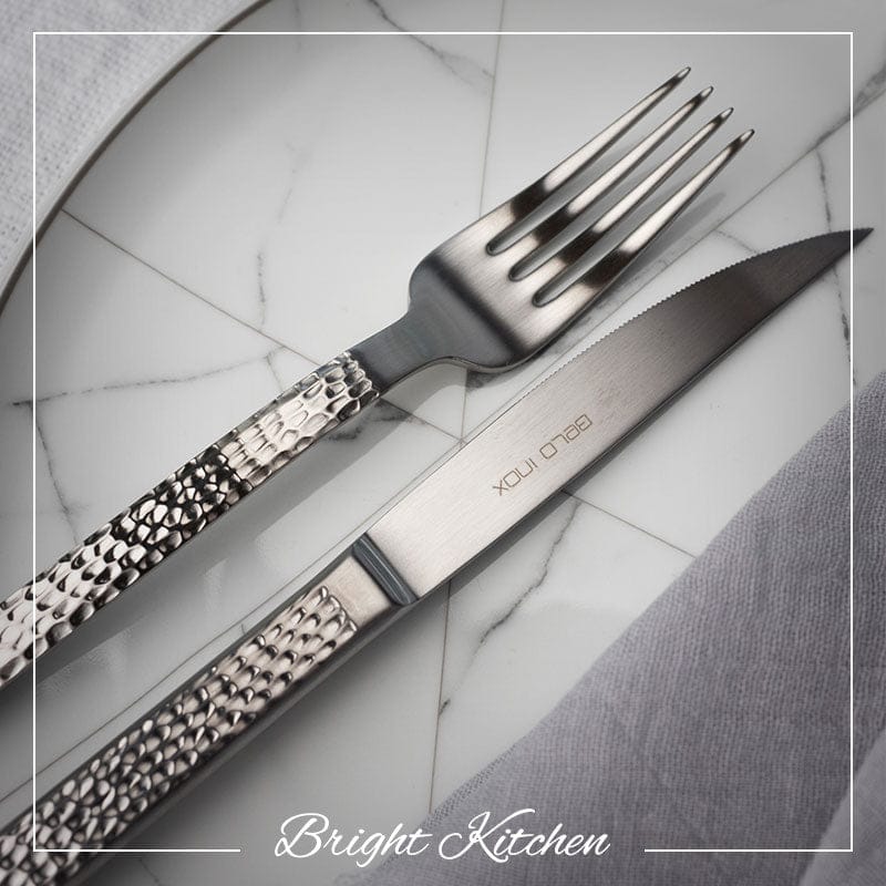 Belo Inox Skin cutlery set with textured handles displayed on an elegant marble table setting, photographed by Bright Kitchen